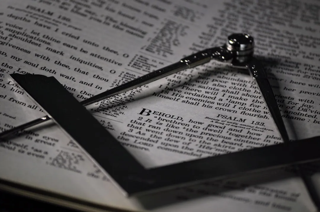 Cross on an open book signifies knowledge, paralleling Masonic symbols.
